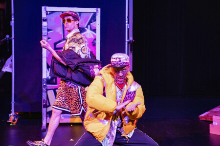 Die beiden Schauspieler machen eine Show, sie sind schrill und bunt angezogen und machen einen auf wild.